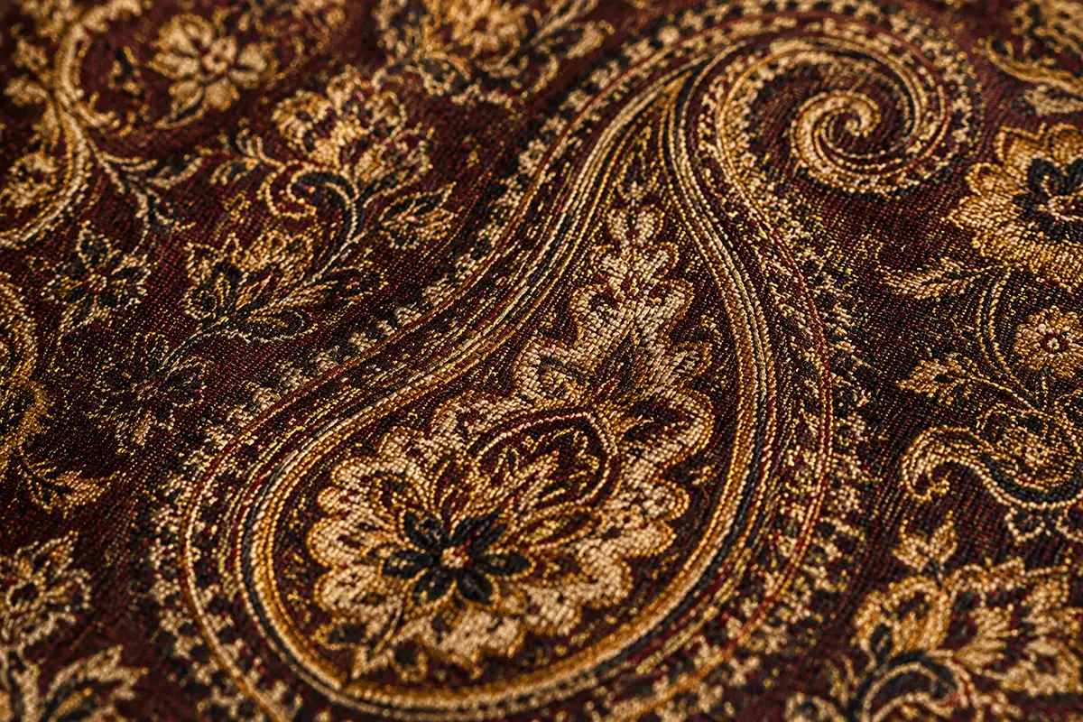 Close up of handwoven termeh fabric showing intricate paisley boteh pattern and silk thread detail